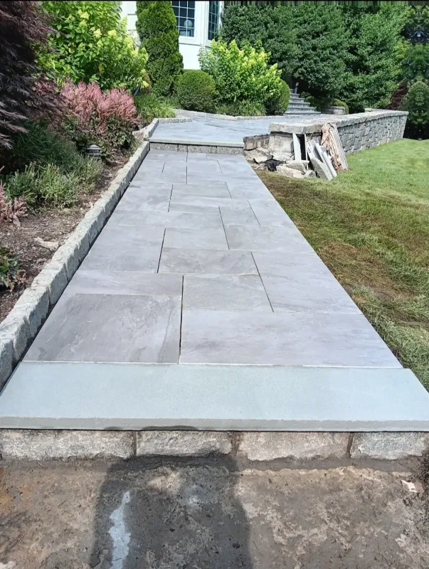 New stone pathway with landscaping and retaining walls.