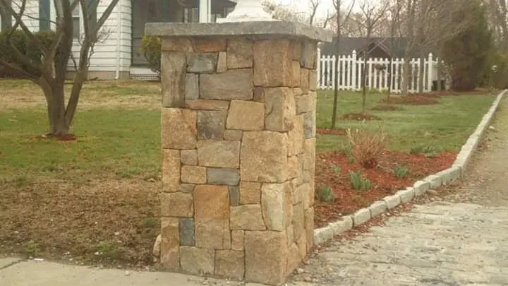 Stone pillar with capstone at property entrance.