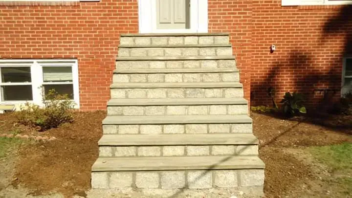 Stone steps leading to a brick house entrance.