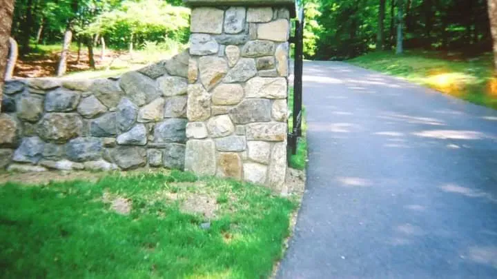 Stone wall and driveway entrance for property.